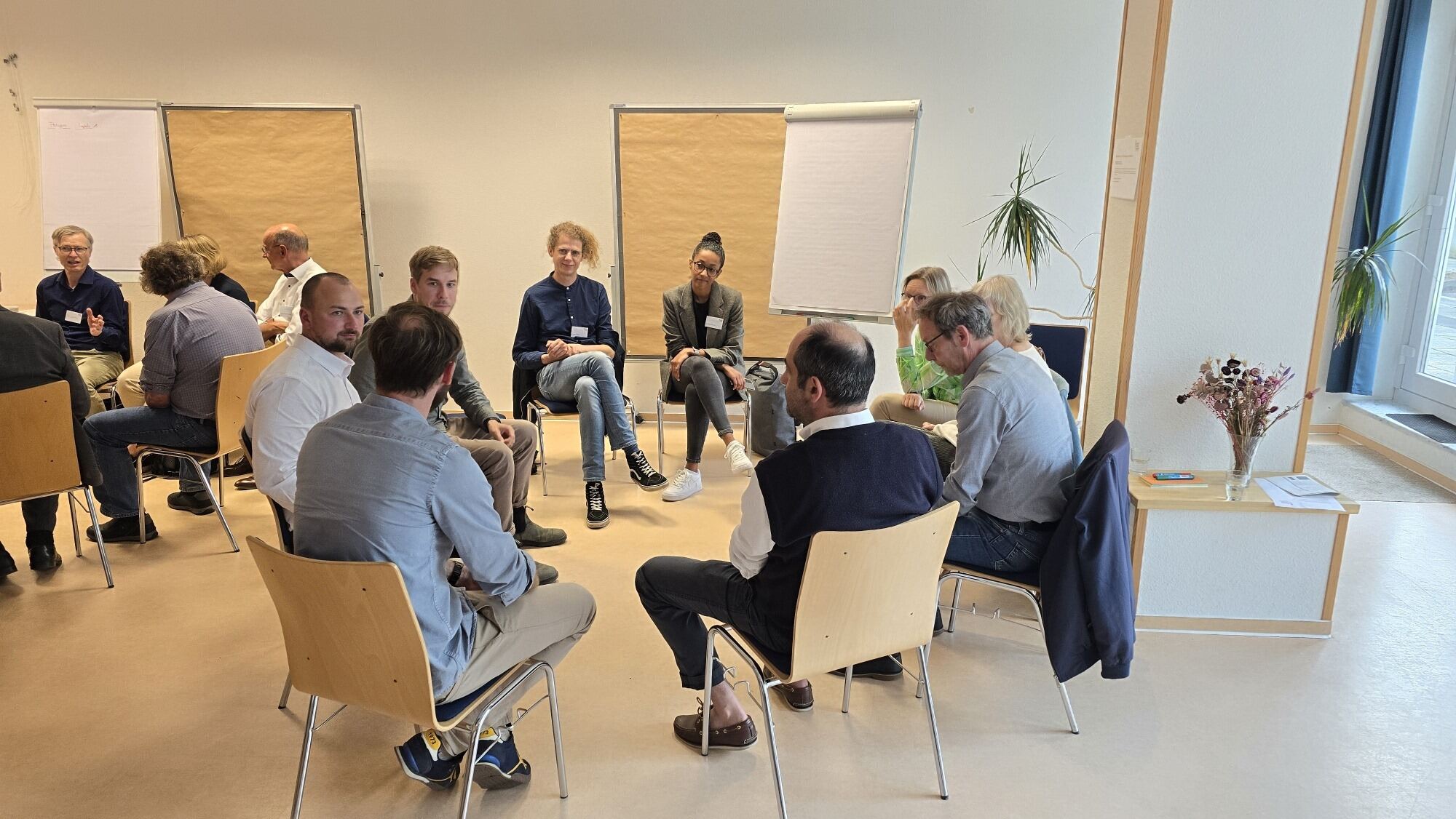 Einige Menschen sitzen in einer Gruppe zusammen und diskutieren